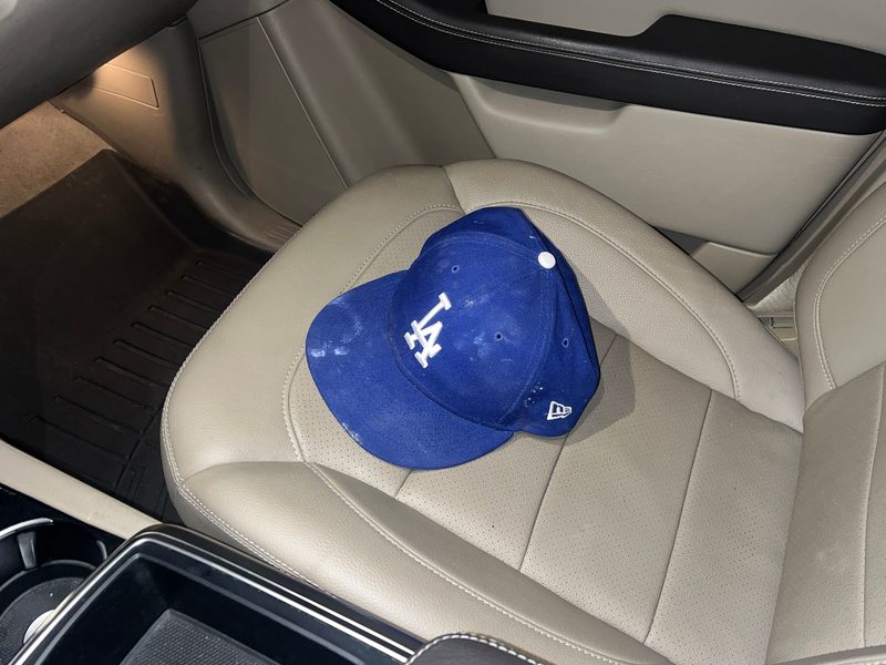 LA Dodgers hat on the passenger seat of a car